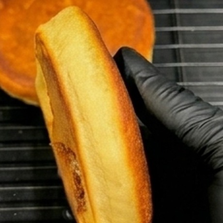 A soufflé pancake held on its side to show its thickness
